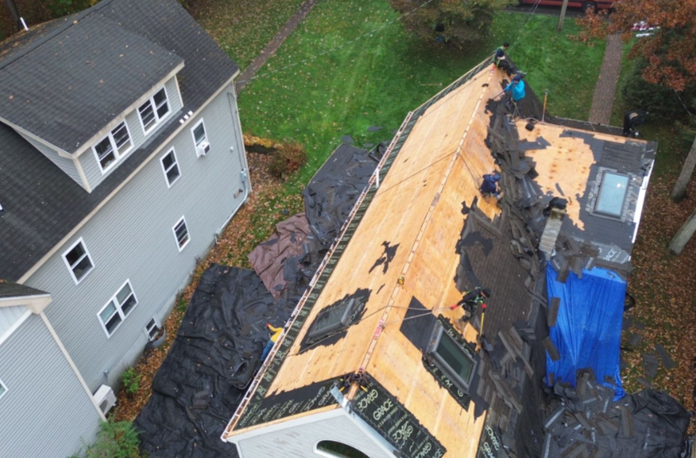 Un profesional de Mighty Dog Roofing de Greater Middlesex County inspeccionando una reparación de techo completado en Westford, MA, asegurando la durabilidad a largo plazo. Reparación de techos cerca de mí.